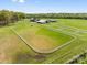 Aerial view of horse farm with multiple paddocks, stables, and open fields surrounded by lush greenery at 15670 Bethel Avenue Ext, Midland, NC 28107