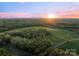 Stunning aerial view of the property at sunset showcasing the expansive land and lush forest at 15670 Bethel Avenue Ext, Midland, NC 28107
