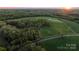 Aerial view of expansive property featuring grassy pasture, fencing and tree lined perimeter at 15670 Bethel Avenue Ext, Midland, NC 28107