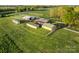Aerial view of farm with multiple outbuildings and fenced pasture at 15670 Bethel Avenue Ext, Midland, NC 28107