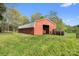 Large red barn with a metal roof and sliding door surrounded by a grassy field at 15670 Bethel Avenue Ext, Midland, NC 28107