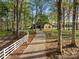 A long, winding driveway leads to a charming brick home nestled among mature trees and lush landscaping at 15670 Bethel Avenue Ext, Midland, NC 28107