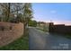 Farm entrance featuring brick columns with decorative gates, a sign, and a long driveway at 15670 Bethel Avenue Ext, Midland, NC 28107
