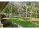 Inviting front yard with lush green lawn, a white fence, and tree lined driveway leading to the home at 15670 Bethel Avenue Ext, Midland, NC 28107