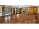 Open-concept living room showcasing a stone fireplace, wooden floors, large windows, and natural lighting at 15670 Bethel Avenue Ext, Midland, NC 28107