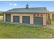 Large outbuilding with three garage doors and decorative wagon wheels, set in a green field at 15670 Bethel Avenue Ext, Midland, NC 28107
