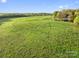 Large, grassy pasture with a charming wooden building in the distance at 15670 Bethel Avenue Ext, Midland, NC 28107