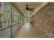 A long porch with brick flooring, ceiling fans, and a view of the lush green landscape at 15670 Bethel Avenue Ext, Midland, NC 28107