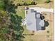Birds-eye view of residence with spacious yard, mature trees, a lovely patio area, and an expansive driveway at 164 Riverstone Dr, Davidson, NC 28036