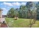 Spacious backyard with plush lawn, mature trees, landscaping, and a patio with hot tub at 164 Riverstone Dr, Davidson, NC 28036