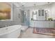Stunning bathroom features a soaking tub, glass-enclosed shower, and double vanity with white cabinetry at 164 Riverstone Dr, Davidson, NC 28036