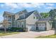 Charming exterior with a three-car garage, complemented by beautiful landscaping and a basketball court for recreation at 164 Riverstone Dr, Davidson, NC 28036
