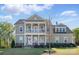 Charming two-story home featuring a covered front porch, upper balcony and well-manicured lawn at 164 Riverstone Dr, Davidson, NC 28036