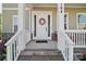 Inviting covered front porch with white columns and railings, featuring a decorative floral wreath on the front door at 164 Riverstone Dr, Davidson, NC 28036