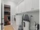 Well-organized laundry room with washer and dryer, white cabinetry, and ironing equipment at 164 Riverstone Dr, Davidson, NC 28036