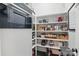 Well-stocked pantry with white shelving, ample storage, and integrated Miele oven display at 164 Riverstone Dr, Davidson, NC 28036