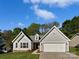 Charming home featuring a well-manicured lawn, attached two-car garage, and neutral-toned siding at 1727 Running Brook Rd, Charlotte, NC 28214