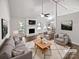 Bright living room with fireplace, ceiling fan, and open floor plan to the dining area at 1727 Running Brook Rd, Charlotte, NC 28214