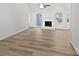 Spacious living room featuring wood-look flooring, a white brick fireplace, and access to the back patio at 1727 Running Brook Rd, Charlotte, NC 28214