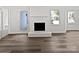Bright living room featuring wood-look flooring, a white brick fireplace, and access to the back patio at 1727 Running Brook Rd, Charlotte, NC 28214