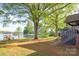 Expansive backyard with mature trees and a glimpse of the lake, offering a serene outdoor space at 235 Commodore Loop, Mooresville, NC 28117