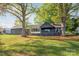 Spacious backyard with lush green grass and mature trees surrounding the charming house at 235 Commodore Loop, Mooresville, NC 28117