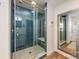 Bathroom featuring a blue tiled shower with a glass door and view of a mirror at 235 Commodore Loop, Mooresville, NC 28117