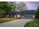 Twilight view of gray single-story home with a well-manicured lawn, attached garage, and inviting front entrance at 235 Commodore Loop, Mooresville, NC 28117