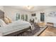Bright main bedroom featuring a bed, accent chair, large window, and ensuite bathroom at 235 Commodore Loop, Mooresville, NC 28117