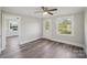 Bedroom with hardwood flooring, with multiple windows offering natural light and backyard views at 2679 Providence Mill Rd, Maiden, NC 28650