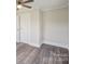 A neutral bedroom features gray floors, a ceiling fan, white trim and paneled doors at 2679 Providence Mill Rd, Maiden, NC 28650