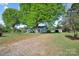 Exterior view of a home and lawn with mature trees and a detached garage at 2679 Providence Mill Rd, Maiden, NC 28650