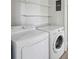 Functional laundry room featuring a white washer and dryer, with storage shelves at 2679 Providence Mill Rd, Maiden, NC 28650