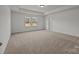 A spacious bedroom features neutral carpeting, two windows and a tray ceiling with recessed lighting at 277 Supernova Dr, York, SC 29745