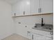 Laundry room with granite counters, stainless sink, plentiful white cabinets, and tile flooring at 277 Supernova Dr, York, SC 29745