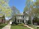 Charming two-story home featuring a welcoming front porch, lush landscaping, and a well-manicured lawn at 307 N Downing St, Davidson, NC 28036