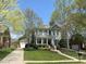 Charming two-story home featuring a welcoming front porch, lush landscaping, and a well-manicured lawn at 307 N Downing St, Davidson, NC 28036