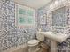 Charming bathroom with unique patterned wallpaper, white fixtures, and a window with shutters at 3324 Champaign St, Charlotte, NC 28210