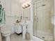 Bright bathroom with pedestal sink, toilet, enclosed shower, and storage cabinet at 3324 Champaign St, Charlotte, NC 28210