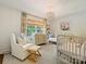 Charming Bedroom with white crib, glider chair, and decorative chandelier at 3324 Champaign St, Charlotte, NC 28210