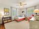 Inviting bedroom with neutral decor, two windows, fan, decorative pictures, and small book case at 3324 Champaign St, Charlotte, NC 28210