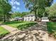 Traditional home with lush lawn, mature trees, and a long driveway to a detached garage at 3324 Champaign St, Charlotte, NC 28210