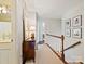 Well-lit hallway with hardwood railing, decorative mirror and lamp, and several framed photos at 3324 Champaign St, Charlotte, NC 28210