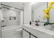 Modern bathroom with marble tiled shower/bath, white vanity, and contemporary fixtures and decorative elements at 3423 Archer Ave, Charlotte, NC 28217