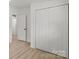 Bedroom featuring closet and access to other rooms, with hardwood flooring throughout at 3423 Archer Ave, Charlotte, NC 28217
