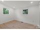 Bedroom featuring hardwood floors, fresh white walls, bright windows, and natural light at 3423 Archer Ave, Charlotte, NC 28217