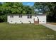 Well-maintained single-story home with white paint, brick steps, and vibrant green lawn at 3423 Archer Ave, Charlotte, NC 28217