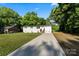Spacious single-story home with a long driveway, fresh paint, and lush green lawn at 3423 Archer Ave, Charlotte, NC 28217