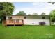 Side view of white home and wooden deck and expansive backyard at 3423 Archer Ave, Charlotte, NC 28217