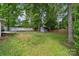 Spacious backyard featuring a storage shed, mature trees, and a well-maintained lawn at 3725 Dunwoody Dr, Charlotte, NC 28215